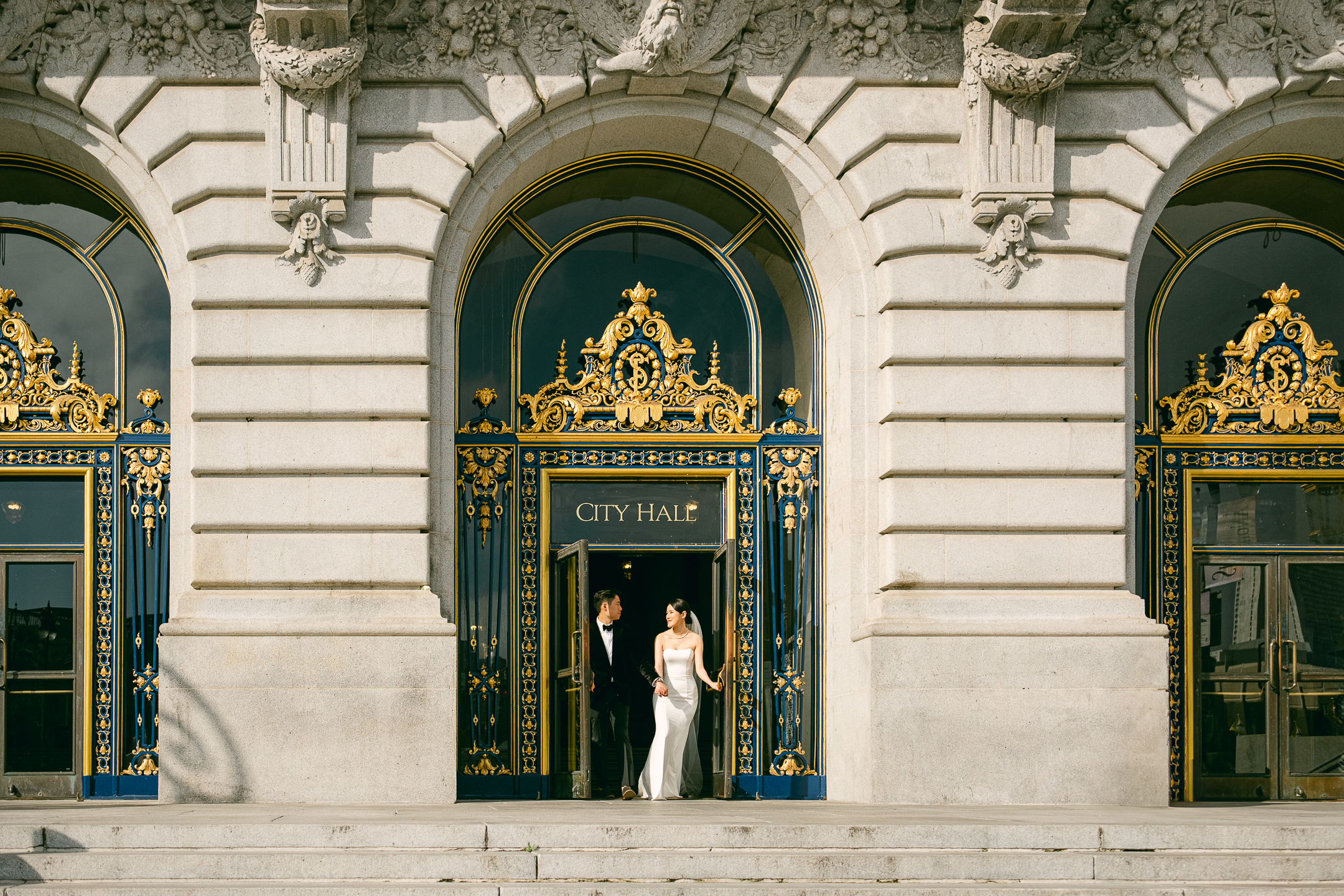Bride and groom exit the courthouse building after their San Francisco City Hall civil ceremony