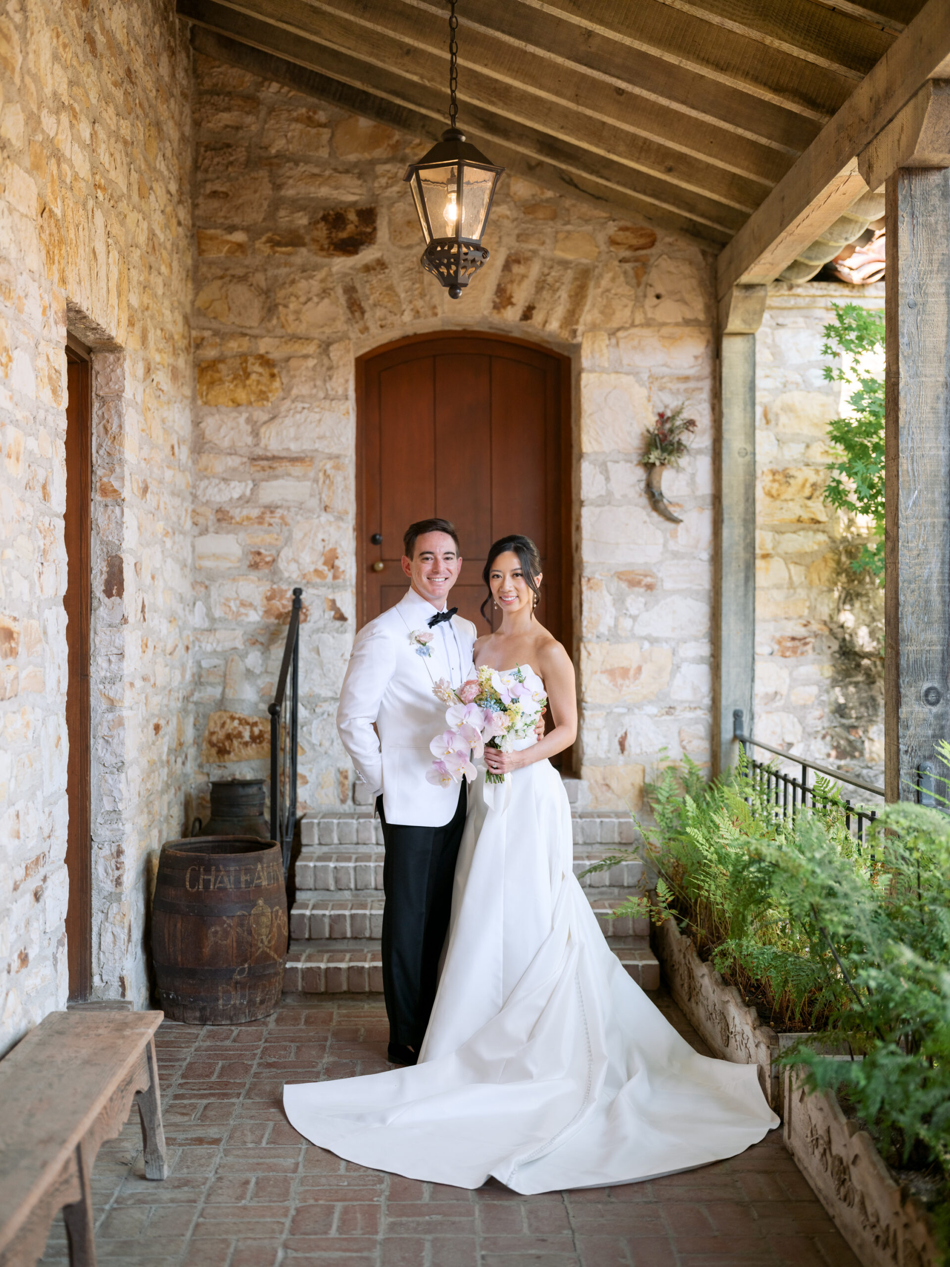 Bride and groom pose for a portrait in the inner courtyard of Holman Ranch, a Carmel wedding venue