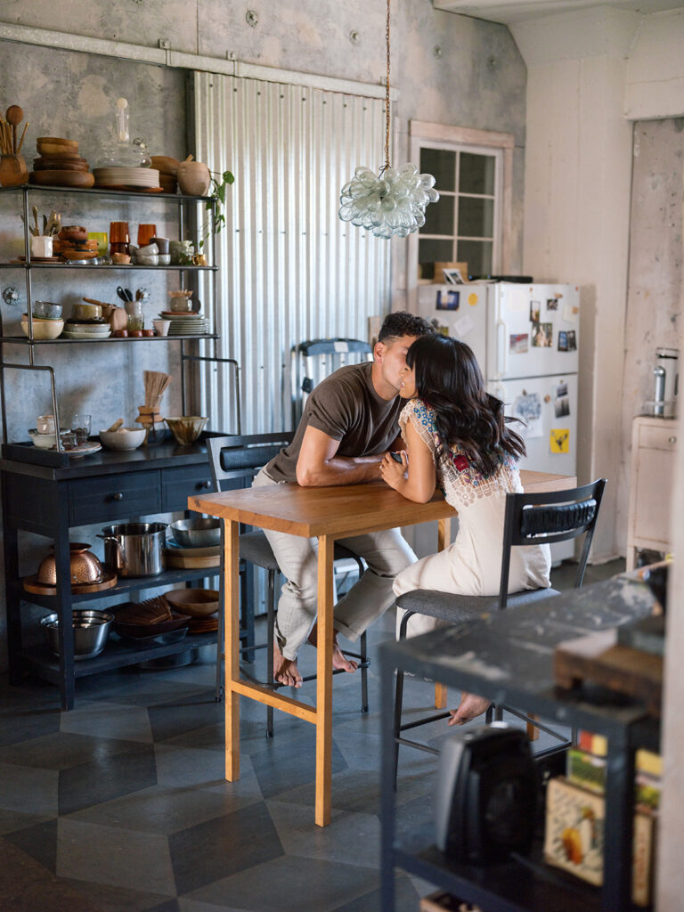 Bride to be and groom to be lean in for a kiss during their lifestyle engagement session