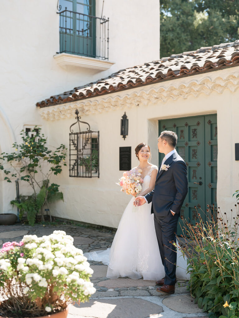 Bride and groom head towards their ceremony at the Allied Arts Guild, a Bay Area wedding venue featuring gardens amongst Spanish architecture