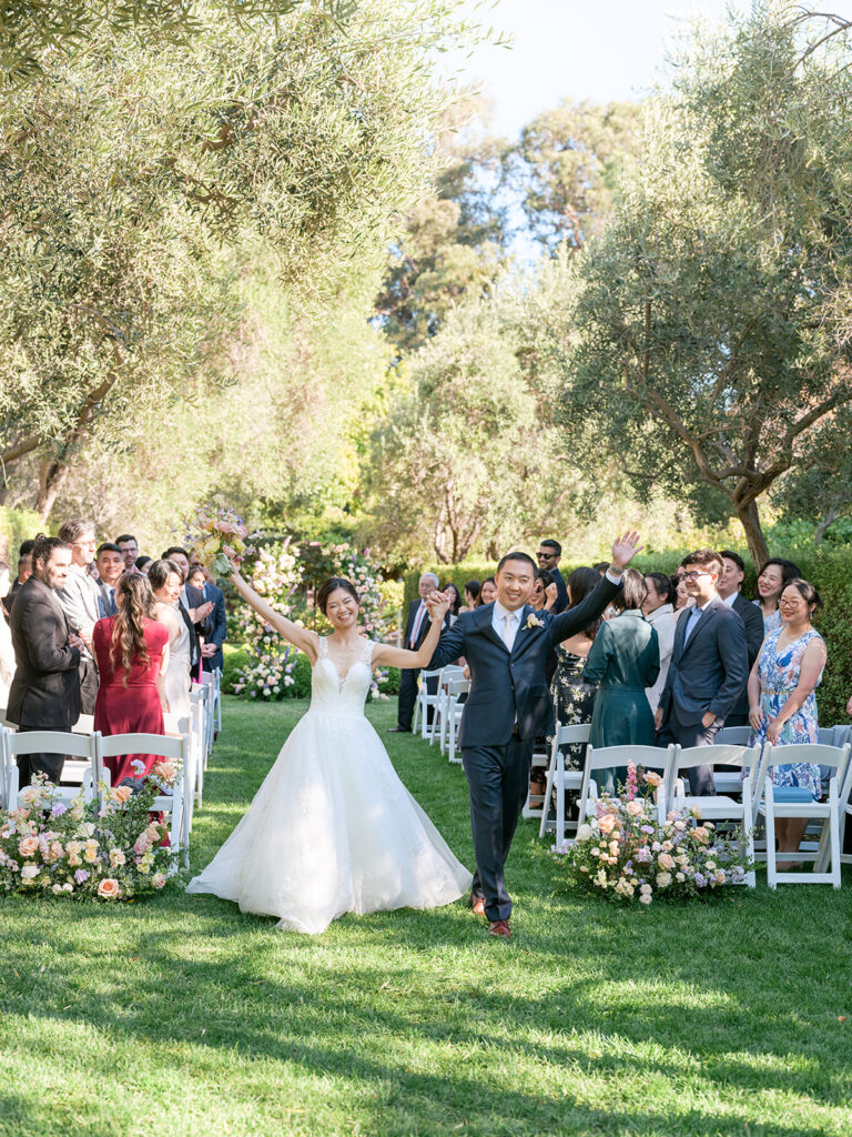 bride and groom joyfully exit their recessional at their Allied Arts Guild wedding, a romantic garden venue in the San Francisco Bay Area