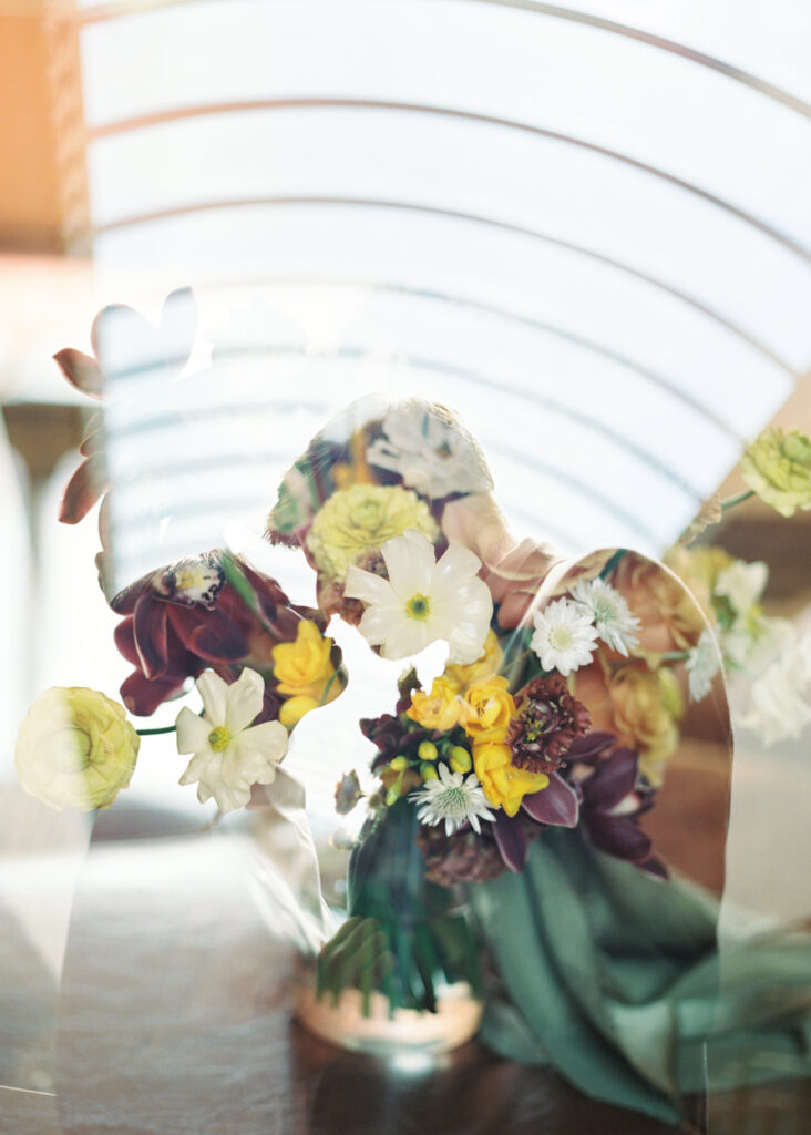 double exposure on film of the bride and groom leaning in for a kiss, with a view of the Marin County Civic Center sky lights