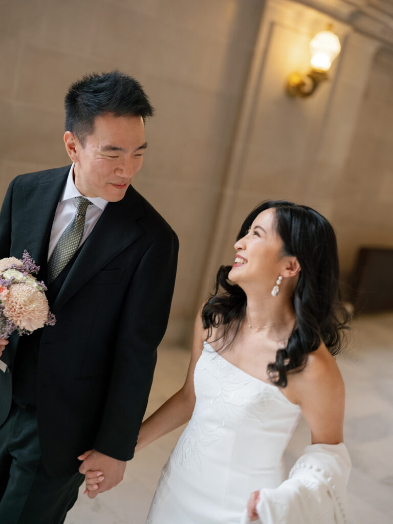 bride and groom walking joyfully down the hallway at San Francisco City Hall