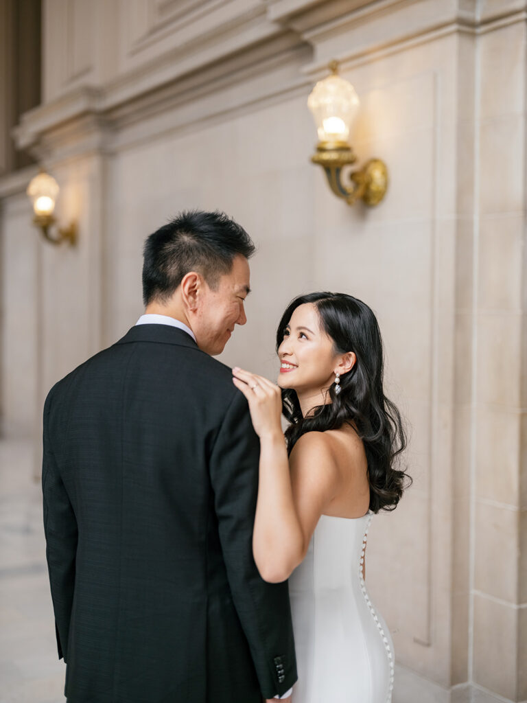 bride and groom sharing a quiet moment at SF City Hall, bride placing her hand on the groom's shoulder