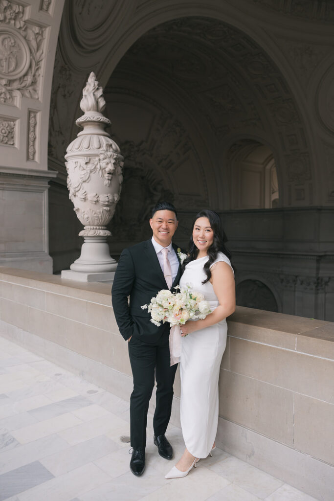 Bride and groom portrait beside the stone urn under the colonnade arches, San Francisco City Hall wedding photography
